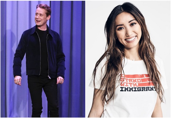 macaulay culkin priveste intr-o parte si sta in picioare, iar brenda song zambeste larg si priveste inainte