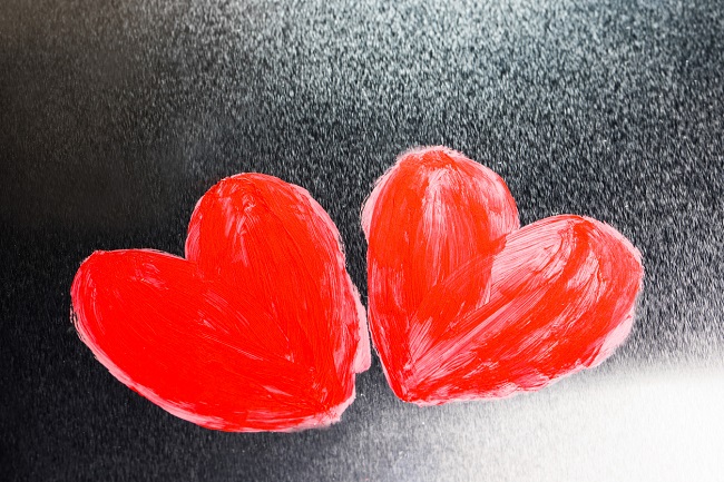 ilustratie cu doua inimi rosii, pe un fundal negru cu alb