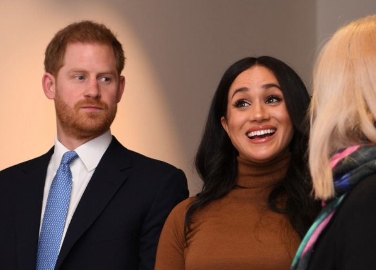 meghan markle zambeste larg, in timp ce printul harry o priveste dintr-o parte