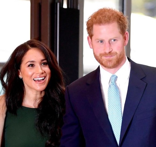 printul harry priveste in fata, in timp ce meghan markle zambeste larg