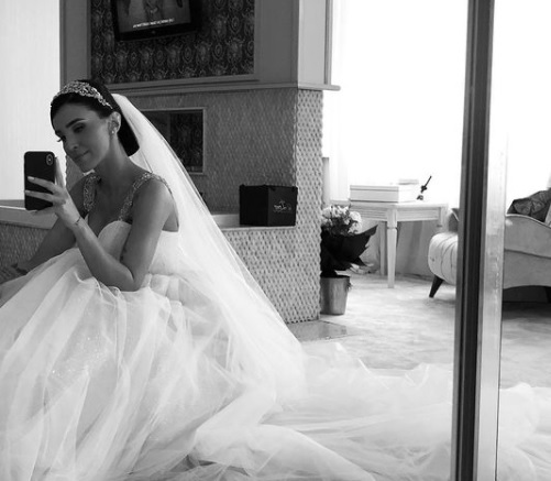 adelina pestritu isi face un selfie in oglinda, imbracata in rochia de mireasa