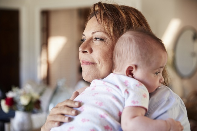 o mama in varsta isi tine la piep bebelusul si zambeste