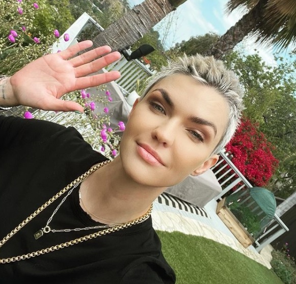 ruby rose zambeste si priveste drept inainte si tine o mana ridicata