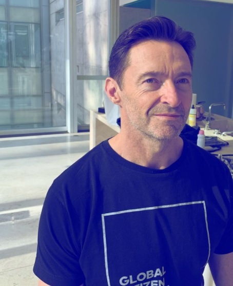 hugh jackman sta in picioare si priveste intr-o parte