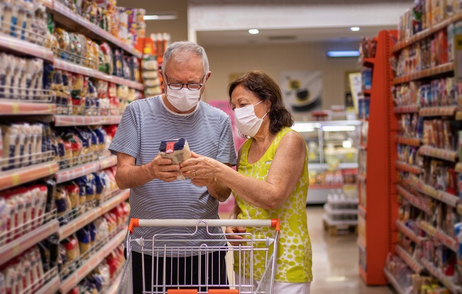 doi oameni cu masca de protectie sunt la cumparaturi in supermarket