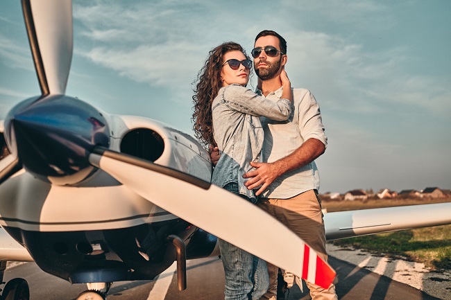 o femeie si un barbat stau imbratisati, pe un aeroport