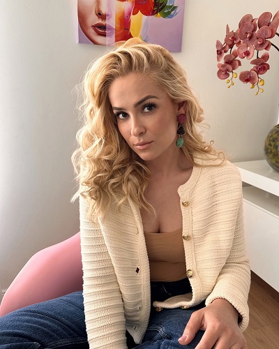 Elena Viscu, fosta sotie a lui CRBL, purtand pulover crem si blugi