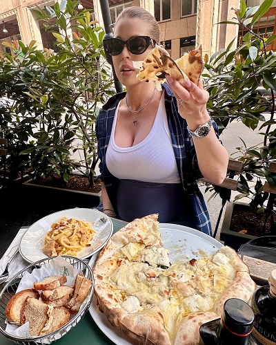 Roxana Nemeș ținând în mână o felie de pizza