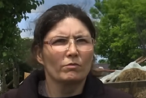 femeie cu ochelari si parul lung, imbracata in negru