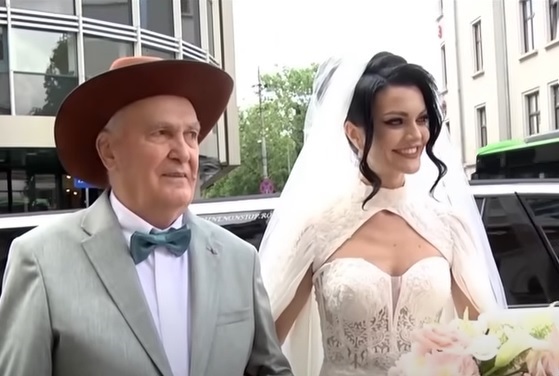 Magdalena Chihaia, soția lui Dinu Maxer, venind alaturi de tatal ei la ceremonia religioasa de la nunta