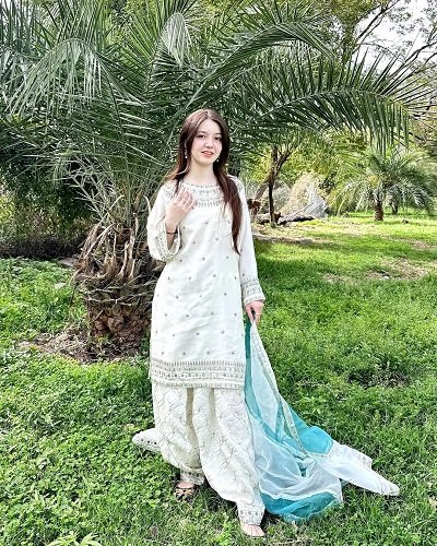 Sana Yousaf in costum traditional intr-o gradina cu palmieri