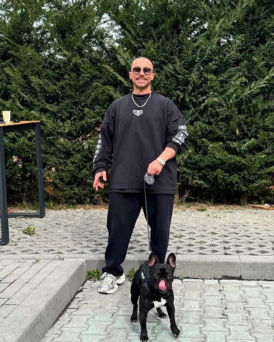 Catalin Dobrescu imbracat sport si tinand in lesa un caine