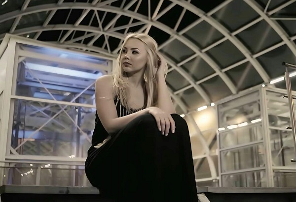 Denisa Răducu &icirc;n rochie neagră st&acirc;nd pe jos pe o scenă