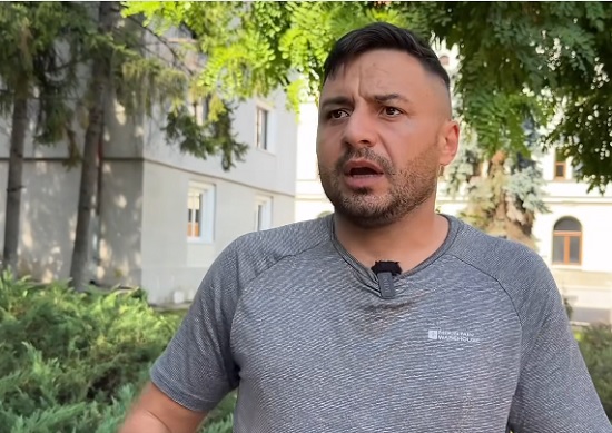 bărbat furios în fața unui bloc imbracat in tricou gri