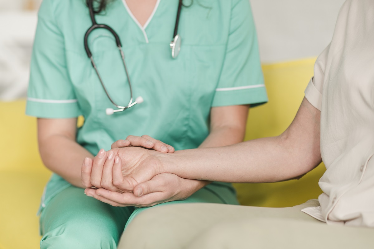 medic care tine intre palme mana unui pacient