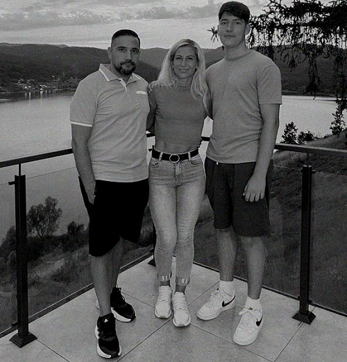 Fabian Căprău alături de părinții lui, Claudia și Alin, in poza alb negru cu spatele la o apa