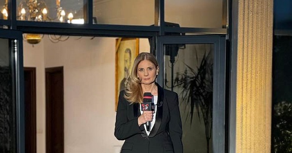jurnalista Anca Alexandrescu imbracata int costum negru, tinand microfonul in mana in timpul unei transmisiuni in direct pentru postul TV la care lucreaza 