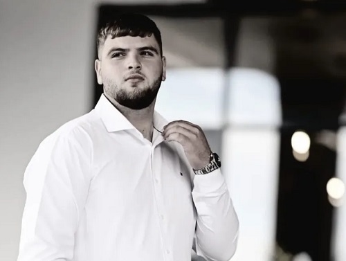 fotografie alb-negru, Vlădut Crisan, tanarul de 18 ani din Satu Mare mort in conditii suspecte, imbracat cu camasa alba cu maneca lunga si purtand ceas la mână