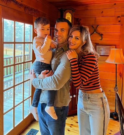 Beatrice Andrei, fosta membra a trupei Like Chocolate, fericita, imbracata cu bluza in dungi si blugi, alaturi de soțul și de fiul ei la o cabană
