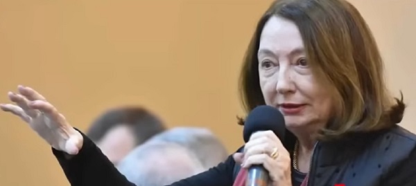 fostul ministru al Justitiei Rodica Stanoiu imbracata cu vesta matlasata neagra, cu bluza cu maneca lunga neagra, tinand in mana un microfon si cu cealalta gesticuland