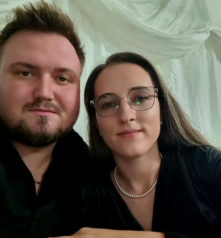 Preotul Constantin Mandruta imbracat in negru alaturi de sotia lui, Georgiana, purtand ochelari si colier de perle la gat, fiind imbracata tot in negru