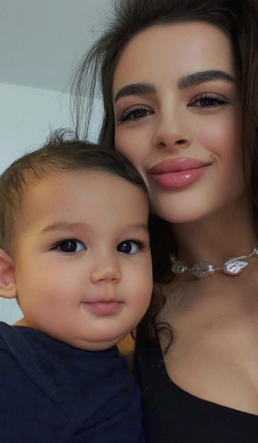 Oana Ciocan, sotia lui Jador, zambitoare, imbracata cu un top negru decoltat, purtand la gat un sirag de perle artificiale, stand alaturi de fiul lor, Avraam, imbracat in bleumarin