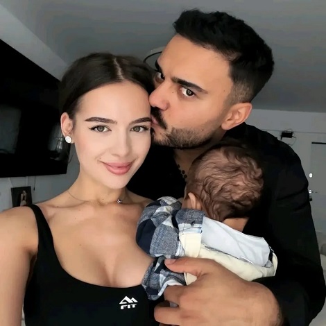 Jador acasa, imbracat cu bluza neagra, tinandu-si in brate fiul, Avraam si sarutandu-si pe frunte sotia, Oana Ciocan, imbracata cu un top decoltat negru si purtand un colier delicat, la baza gatului