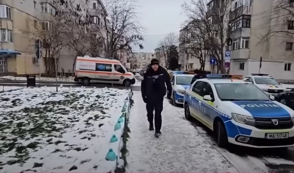ambulanta și masini de politie parcate in zona unor blocuri dintr-un cartier din Constanta, politist in uniforma care se indreapta spre blocul in care a fost anuntat ca un barbat si-ar fi injunghiat mama