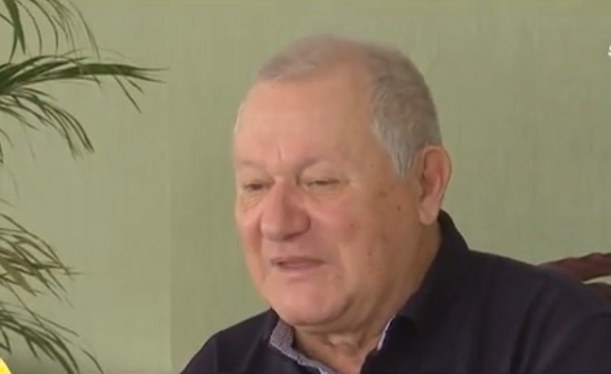 omul de afaceri Cristian Ț&acirc;nțăreanu imbracat cu camasa neagra, stand pe scaun intr-un spatiu interior, langa el aflandu-se o planta exotica, acordand un interviu 