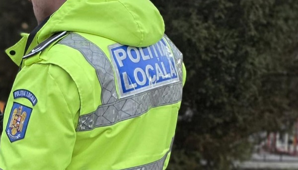 politist din cadrul Politiei Locale din județul Iași, fotografiat cu spatele, purtand uniforma, aflandu-se in misiune