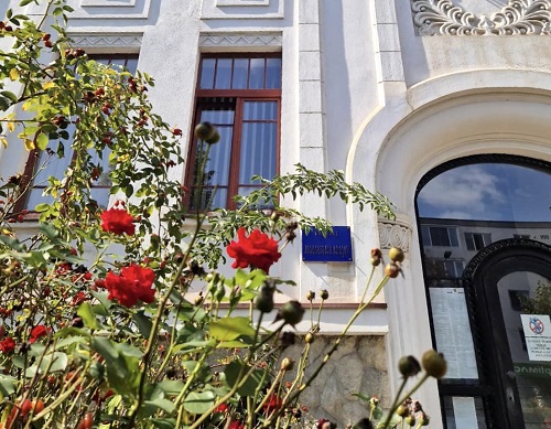 cladirea Judecatoriei Brasov, in fata cladirii fiind tufe cu trandafiri roșii