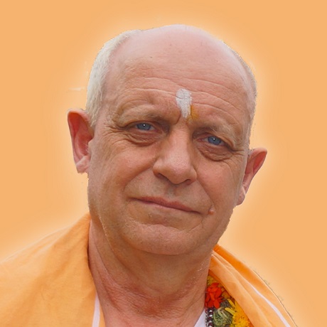 portret Craig Hamilton-Parker imbracat in costum traditional Indian, cu sal portocaliu si cu flori la gat, avand pe frunte semnul alb indian asociat de obicei cu credinta in cel de-al treilea ochi