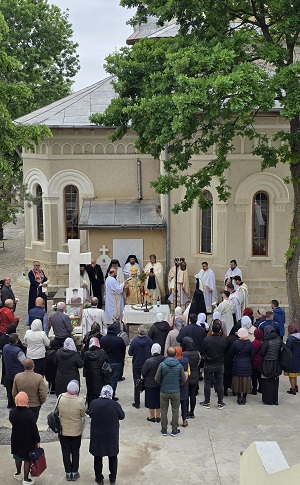 imagine din curtea Mănăstirii Dervent, județul Constanța, unde se află atât preoți care oficiază o slujba, cât și credincioși care participă la slujbă