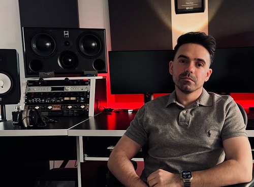 Compozitorul si producatorul muzical Cristian Tarcea, imbracat cu tricou maroniu, stand serios pe scaun in studioul sau