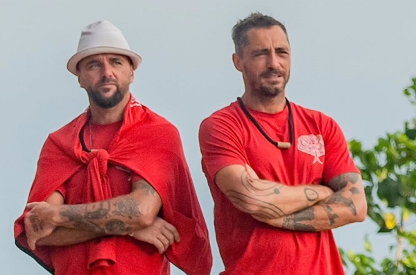 Dumbo, pe numele sau real Marius Alexandru, alaturi de Vladimir Draghia, amandoi imbracati in rosu, stand cu bratele incrucisate, in aer liber, intr-un cadru cu copaci in cadrul competitiei Desafio:Aventura