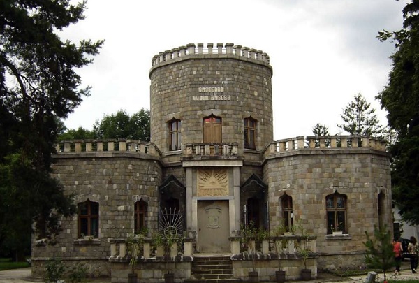 Castelul Iulia Hasdeu de la Campina, vazut din afara, inconjurat de copaci, in curtea castelului aflandu-se doua femei