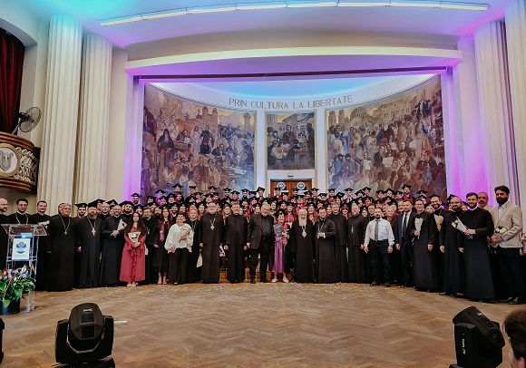 imagine de la ceremonia de absolvire a Facultatii de Teologie Ortodoxa din cadrul Universitatii Babes-Bolyai din Cluj-Napoca, absolventi si cadre didactice aflandu-se pe scena