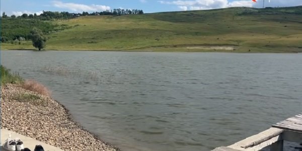 captura video, filmari de dupa tragedia de pe iazul Polonic din Dorohoi, unde s-a inecat un baiat de 14 ani,malurile iazului, unul cu pasuni si copaci si celalalt mal cu pietris, pe malul cu pietris aflandu-se si doua perechi de adidasi