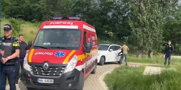 captura video de la tragedia de pe iazul Polonic din Dorohoi,masina de pompieri SMURD pe o alee pietruita, langa alee fiind spatii verzi cu copaci, iar langa masina de pompieri stand doi politisti,in spatele masinii de pompieri fiind si un autoturism alb si doi barbati