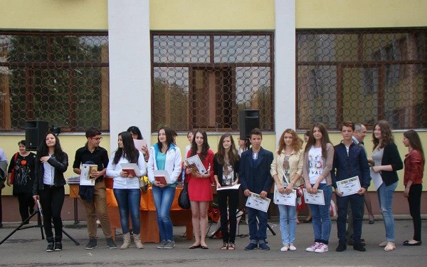 grup de elevi cu diplome la festivitatea de premiere,stand in curtea Colegiului National Nichita Stanescu din Ploiesti