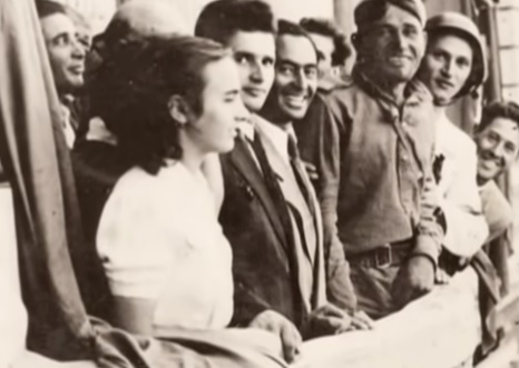 captură video YouTube, sursa oficială fototeca online a comuniscului romanesc, fotografie alb-negru cu Elena Ceausescu in tinerete, alaturi de Nicolae Ceausescu si de alte persoane, stand la un balcon, inainte ca Nicolae sa devina presedinte