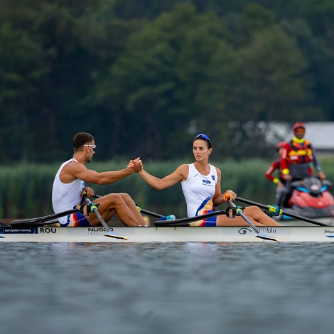 Iulia Bălăucă și Marian Enache, aflati in barca la finalul probei din cadrul Campionatelor Europene de la Varese, strangandu-si mainile deoarece au obtinut medalia de aur in proba de dublu mixt