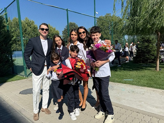 Anca Serea fericita, purtand ochelari negri de soare, alaturi de sotul ei, Adi Sina, imbracat cu sacou negru si pantaloni albi, si de cinci dintre copiii lor, imbracati in uniforme, la inceputul anului scolar din 2025