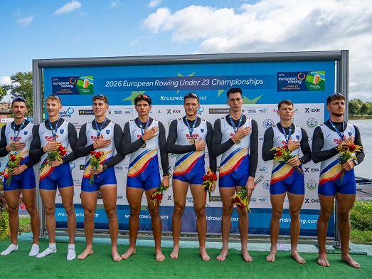 sportivii romani medaliati cu aur la proba de 8+1 masculin din cadrul Campionatelor Europene de Canotaj din Polonia, la festivitatea de premiere, imbracati in echipament, cu medalii la gat, buchete de flori in mana si tinand mana in dreptul inimii in timp ce ascultau imnul Romaniei