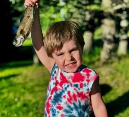 Theo Sabo, baietelul care a murit dupa ce a fost gasit inconstient in masina, imbracat cu tricou rosu cu albastru, tinand in mana un peste