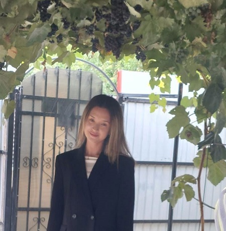 Melisa Seic, tanara de 19 ani din Constanta care a murit, imbracata cu bluza alba si cu sacou negru, in timp ce se afla langa o poarta, sub o bolta de vita de vie
