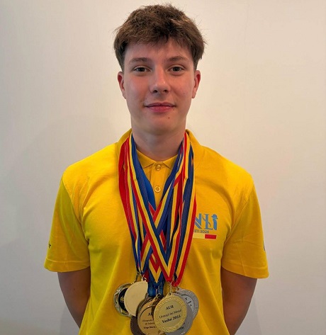 Alexandru Thury-Burileanu,elevul care a obtinut medalia de aur la Olimpiada Internationala de Inteligenta Artificiala, zambitor,imbracat cu tricou galben, avand la gat mai multe medalii