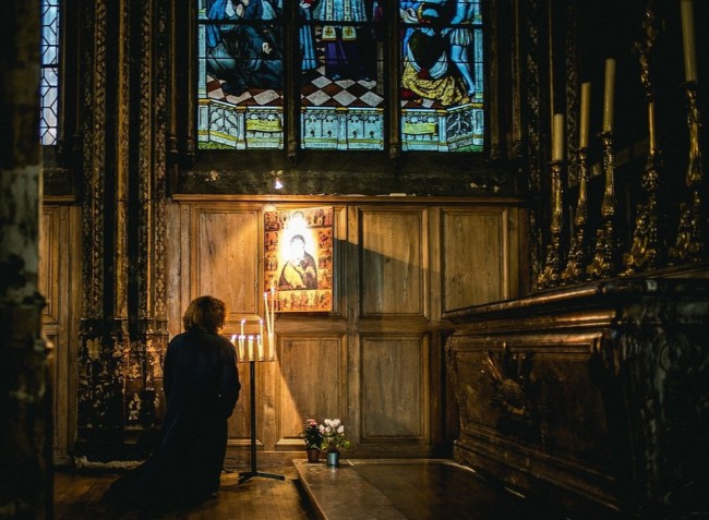 Femeie rugandu-se in biserica