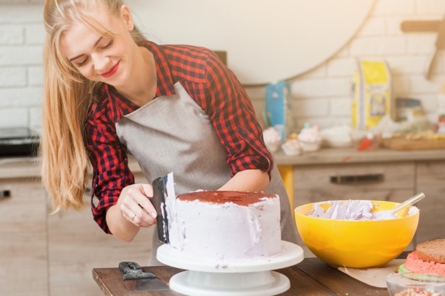 Femeie care decoreaza un tort