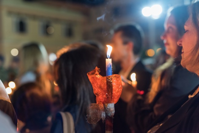 Femeie cu lumanare aprinsa in noaptea de Paste